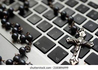 Catholic Rosary Beads On A Laptop Keyboard.