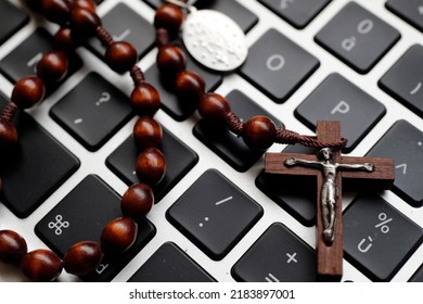 Catholic Rosary Beads On A Laptop Keyboard.