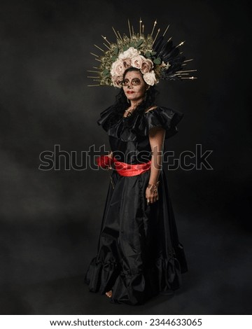 Catrina wearing a black dress. Mexican woman with catrina makeup. Day of the dead and halloween makeup.