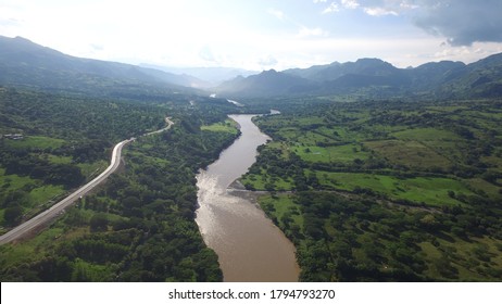The Cauca River as it passes through Puente Inglesias to the southwest of Antioquia in Colombia. On its left side, the fourth generation road between Antioquia and the Colombian Coffee Region. - Shutterstock ID 1794793270