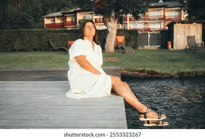 Caucasian adult female relaxing on lakeside dock at sunset - Powered by Shutterstock