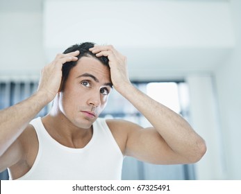 caucasian adult man checking hairline. Horizontal shape, head and shoulders, front view, copy space - Powered by Shutterstock