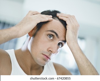 caucasian adult man checking hairline. Horizontal shape, head and shoulders, front view - Powered by Shutterstock