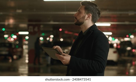 Caucasian adult man driver supervisor inspector investor businessman entrepreneur engineer inspecting underground parking check security measures with digital tablet use navigation on electronic pad - Powered by Shutterstock