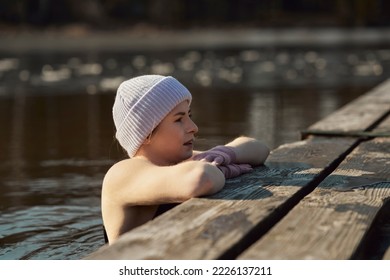 Caucasian adult woman swimming in frozen lake and leaning on wooden pier - Powered by Shutterstock