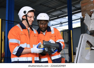 Caucasian and african american development engineer testing artificial intelligence robot arm at high technology research manufactue with equipment. Factory workers working with adept robotic arm. - Powered by Shutterstock