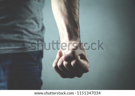 Caucasian angry and aggressive man threatening with fist.