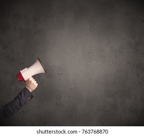 Caucasian Arm Holding Megaphone With Plain Grunge Background