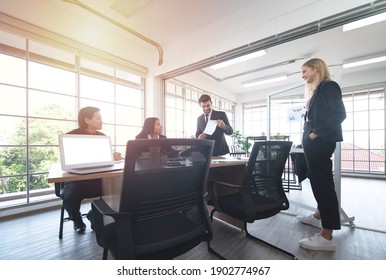 Caucasian Asian business man giving a presentation to associates in meeting room. - Shutterstock ID 1902774967