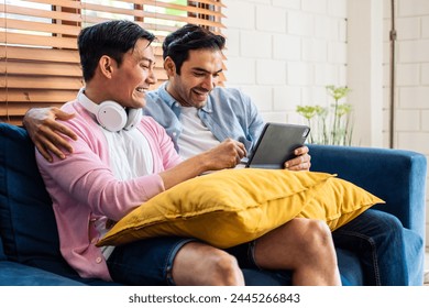 Caucasian attractive gay couple using tablet watch movie in living room. Handsome young man LGBTQ family sitting on sofa, using laptop computer chatting and doing online shopping together in house.
 - Powered by Shutterstock