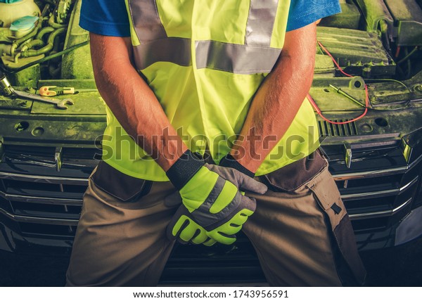 Caucasian Automotive Car Mechanic in\
Front of Vehicle. Lower Body Section. Car Repair Theme.\

