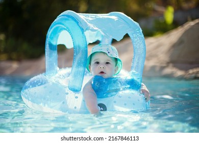 Caucasian baby boy in swimming circle toy swims at pool