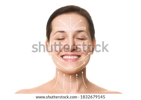 Caucasian beautiful female face with closed eyes, smile and hair up in a bun. Marked with arrows on the main facial lifting lines, front view, isolated on white. Rejuvenation procedure, beautician