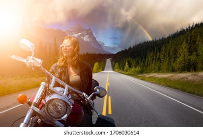 Caucasian Biker Woman On A Motorcycle On A Scenic Road In The Canadian Rockies. Image Composite. Background From Banff, Alberta, Canada.