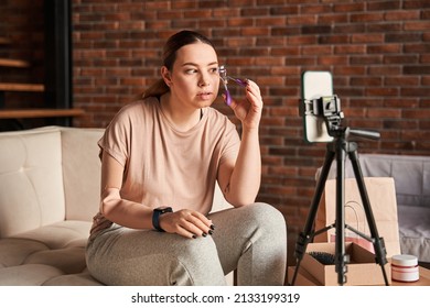 Caucasian Blogger With Amputee Arm Talking To Camera And Showing Lushes Curler