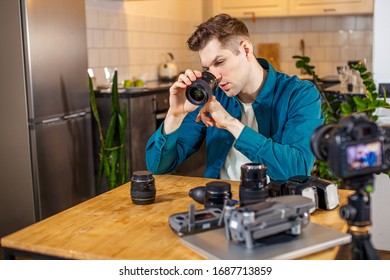 caucasian blogger man studying his new cameras, show DSLR on camera, think which of them is the most useful and desired.