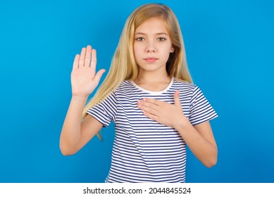 Caucasian Blonde Kid Girl Wearing Stripped T-shirt Against Blue Wall Swearing With Hand On Chest And Open Palm, Making A Loyalty Promise Oath