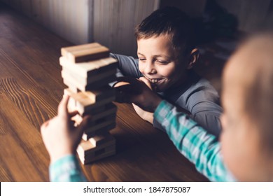 Caucasian Boy And Girl Playing Jenga, Stack Of Wooden Blocks On Dark Brown Table, Children Smiling And Having Fun, Staying At Home During Quarantine, Home Family Activity, Offline Game Concept