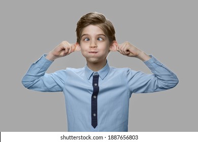 Caucasian boy making monkey face. Close up funny child boy grimacing against gray background. - Shutterstock ID 1887656803