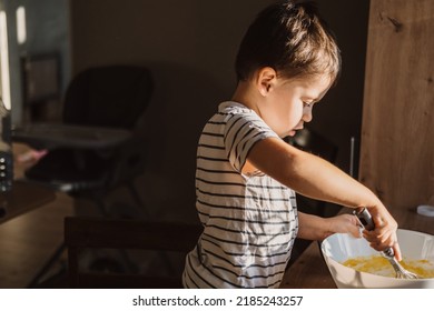 Caucasian Boy Mixing Ingredients For A Cake In Bowl In Kitchen Room. Kid Mixing Sifting Flour Powder In Bowl, Mixing And Beating Dough With Whist.