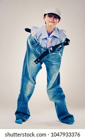 Caucasian Boy Wearing His Dad's Shirt, Jeans And Tie On Light Background. He Is Wearing Big Adult Size Clothes Which Are Too Big For Him.