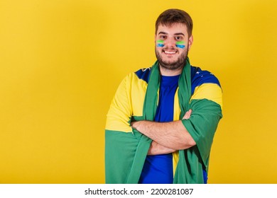 Caucasian Brazilian Man, Brazil Soccer Fan, Arms Crossed, Wearing Brazil Flag Cape.