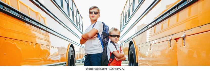 Caucasian Brothers Students Near Yellow School Bus. Cool Kids In Sunglasses Going Back To School In September. Education System And Learning. Support And Friendship. Web Banner Header