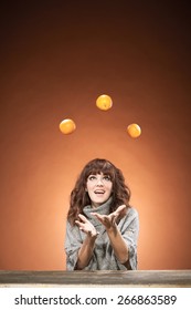 Caucasian Brunette Woman Is Juggling Oranges