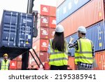 Caucasian business man and woman worker working in container terminal. Attractive engineer people processes orders and product at warehouse logistic in cargo freight ship for import export in harbor.
