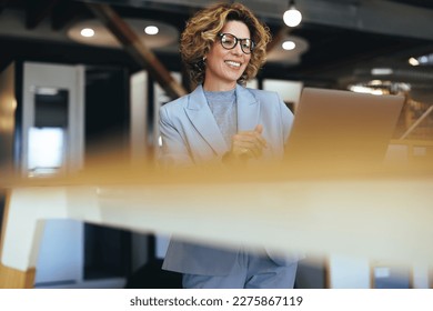 Caucasian business woman having a video call in a coworking office. Professional business woman having an online meeting. Female professional doing remote work with a laptop.