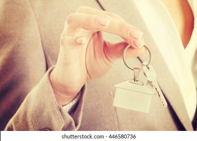Caucasian business woman holds home keys. - Shutterstock ID 446580736