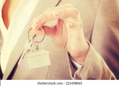 Caucasian business woman holds silver home keys. - Shutterstock ID 221438065