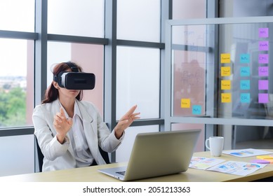 Caucasian business woman are Video conference with Visual reality or VR headset glasses technology in modern office. Metaverse and virtual technology concept. - Shutterstock ID 2051213363