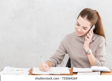 Caucasian Business woman writing down requirement to book   talking and customer in smartphone Feeling so happiness   working and service mind Business   Finance Concept