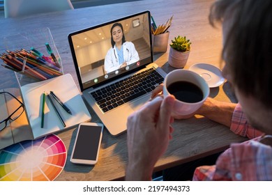 Caucasian Businessman Having Coffee During Video Conference With Asian Female Doctor. Unaltered, Creative Business, Wireless Technology, Working, Healthcare Worker, Healthcare And Office Concept.