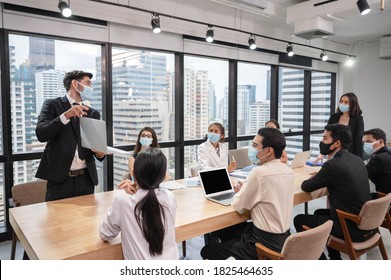 Caucasian Businessman Presentation Of Business Plan On Laptop At Conference Table, Group Of Business People Wearing Face Mask Meeting In Modern Office While Pandemic Of Coronavirus, Covid 19