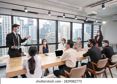 Caucasian Businessman Presentation Of Business Plan On Laptop At Conference Table, Group Of Business People Wearing Face Mask Meeting In Modern Office While Pandemic Of Coronavirus, Covid 19