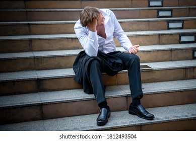 Caucasian Businessmen sitting on concrete stairs, being stressed and tired Because of business problems And unsuccessful, to strain and failure concept.