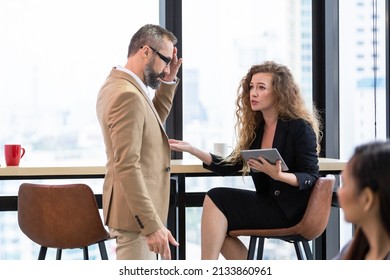 Caucasian Businesswoman Or Customer With Digital Tablet Complaining Work To Male Manager In The Office. Corporate Business Meeting.