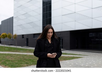 Caucasian Businesswoman Looking At Mobile Phone Outside