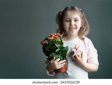 caucasian child girl holding pot with plant and gift box, little kid portrait empty copy space holiday design, cute female with greeting presents.Teacher's day, mother's day. - Powered by Shutterstock