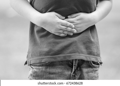 Caucasian Child With Stomach Ache, Boy Holding His Hands On His Belly. Stomach Pain Black And White Stock Image.