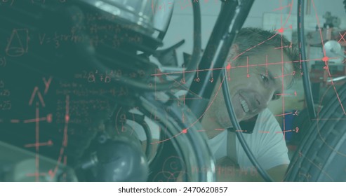 A Caucasian coach with short brown hair, fixing bike, surrounded by equations. Wearing a gray t-shirt, he focuses intently on task - Powered by Shutterstock