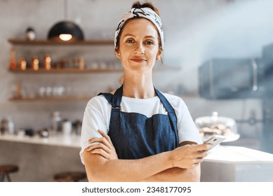 Caucasian coffee shop owner standing in her establishment, embracing technology with her smartphone and using it to streamline operations and provide a modern, efficient experience for her customers.