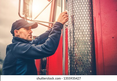 Caucasian Commercial Truck Driver In His 30s And His Red Semi Truck. Automotive Industry.