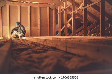 Caucasian Construction Worker in His 40s in the Newly Built Wooden House Attic. Wood Building Theme. 