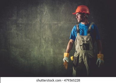 Caucasian Construction Worker Portrait On The Raw Concrete Wall.