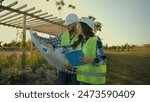 Caucasian contractors engineers colleagues female woman engineer inspector write report hardhat male man worker investor show construction blueprint project checking talking discuss plan farm building