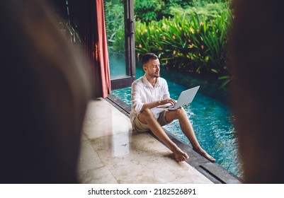 Caucasian Copywriter Using Laptop Application For Creating Content Text During Daytime At Pool Terrace, Skilled Male It Professional Writing Email Messaging While Chatting Via Netbook Technology