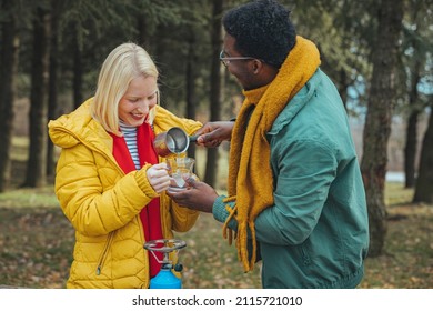 Caucasian couple camping, active romantic couple in love traveling and hiking. Tourists are exploring together. Sunny autumn day. They warm up while drinking hot drinks. Travel concept - Powered by Shutterstock